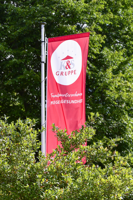 K&S Gruppe Flagge mit Bäumen im Hintergrund